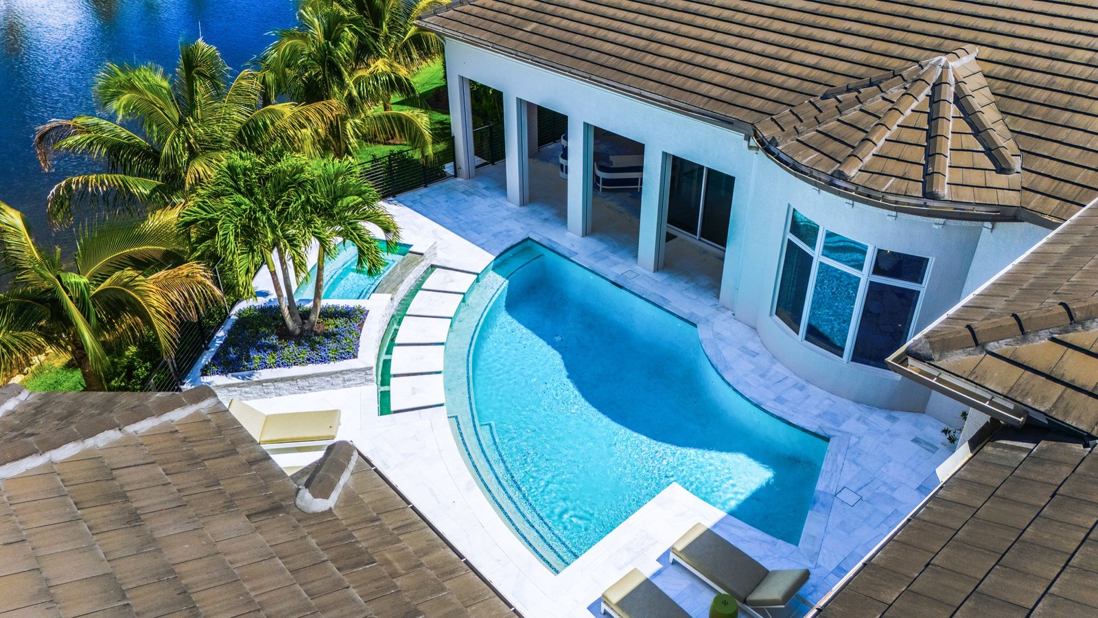 Drone view of a waterfront estate pool and outdoor living area