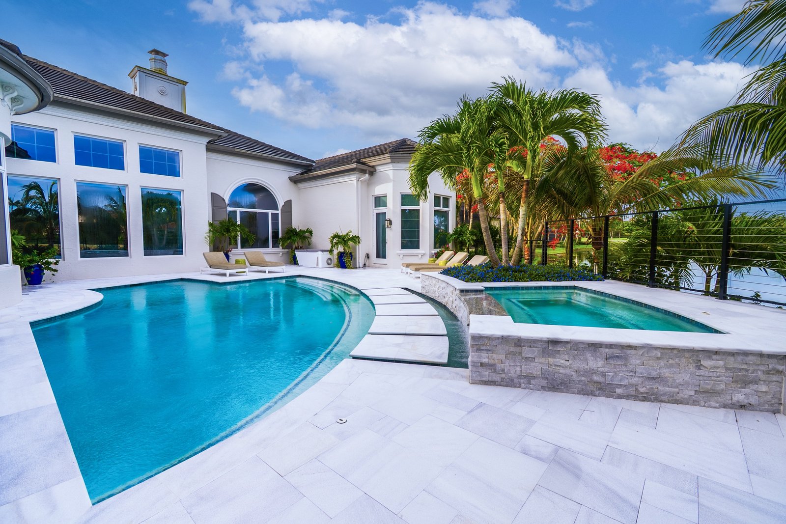 Luxury pool terrace and spa with white deck and estate home