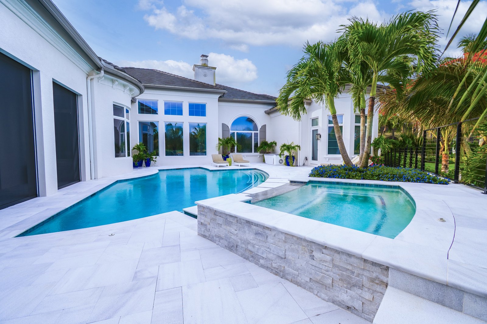 Curved luxury pool and spa with tropical landscaping