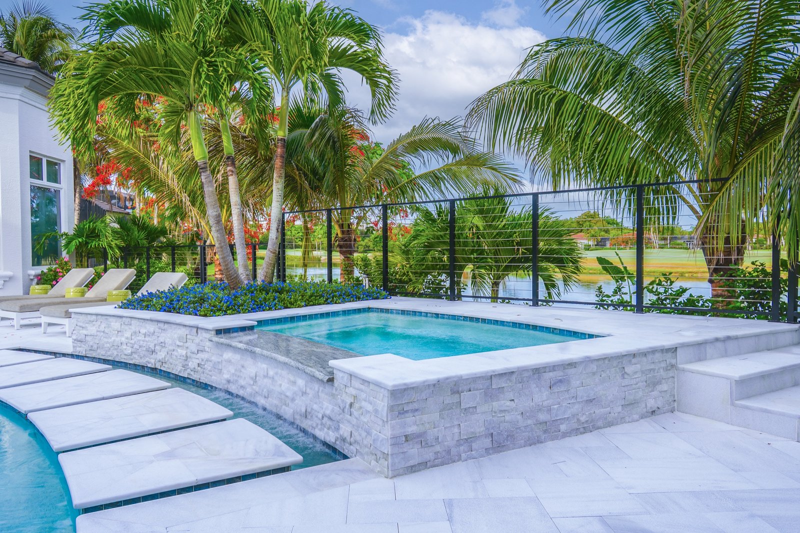 Poolside outdoor living area with lounge seating and palm landscape